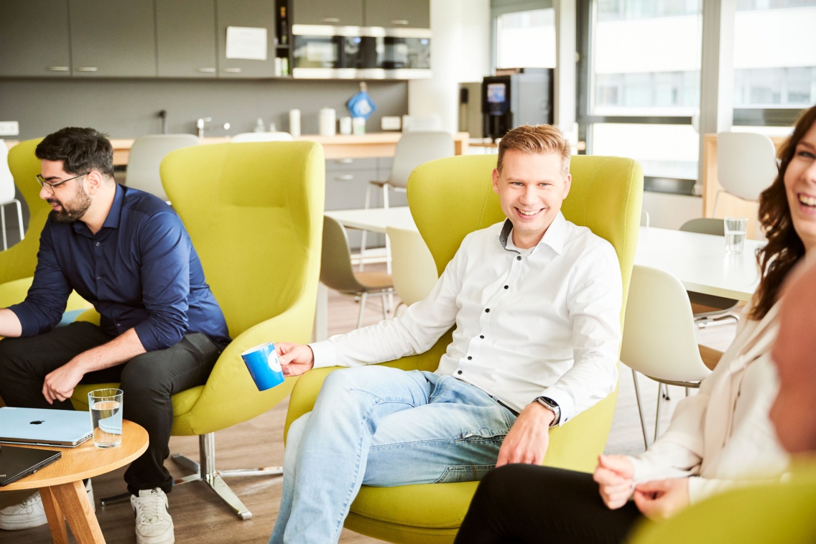 zwei Mitarbeitende am Konferenz Tisch mit Laptop